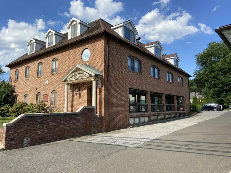 A brick building with a clock on the front of it.